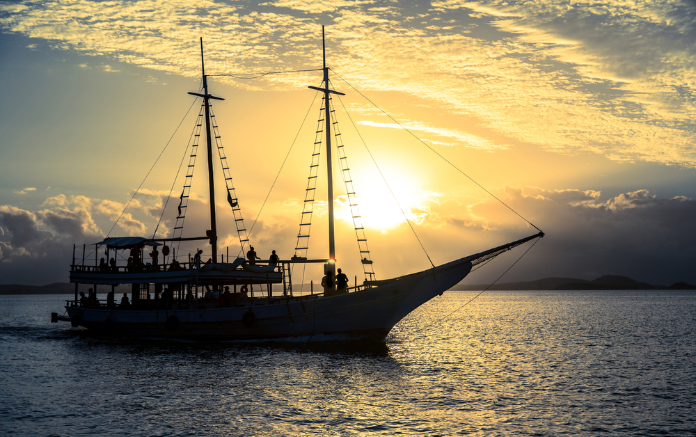 Boat sailing in the sea with a beautiful set sunset behind